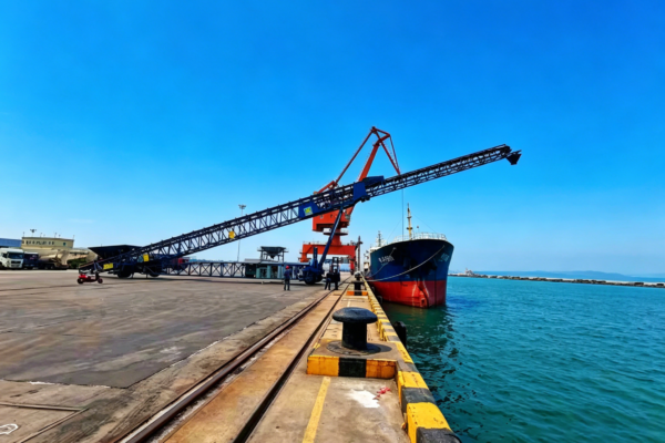 Radial telescopic ship loader loading a bulk carrier at port